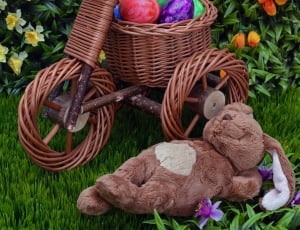 brown rabbit plush toy beside brown wicker trike with easter eggs thumbnail