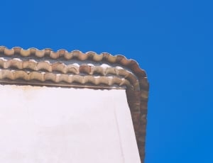low angle photo of roof gutter under calm blue sky thumbnail