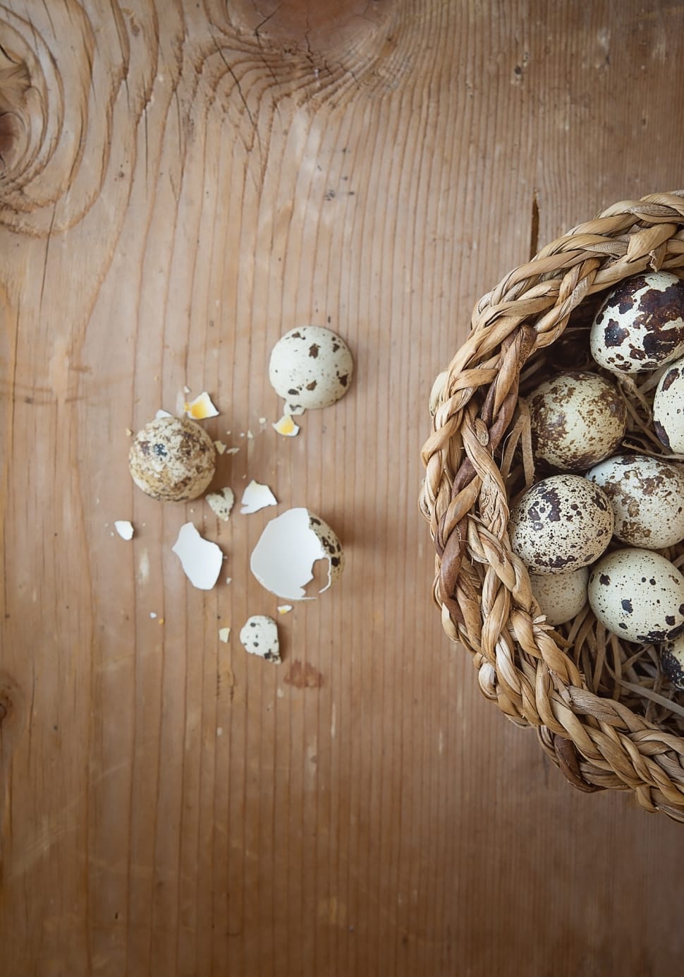 white and brown quail egg with brown wicker basket preview
