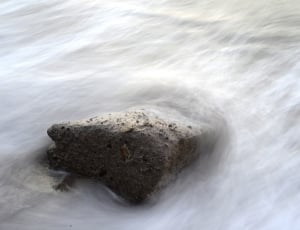 black stone fragment on body of water in timelapse photography thumbnail