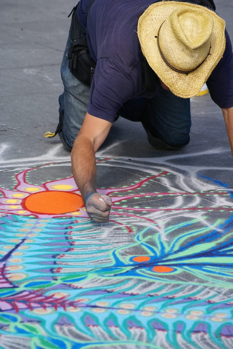 man in blue shirt making a floor art during daytime preview