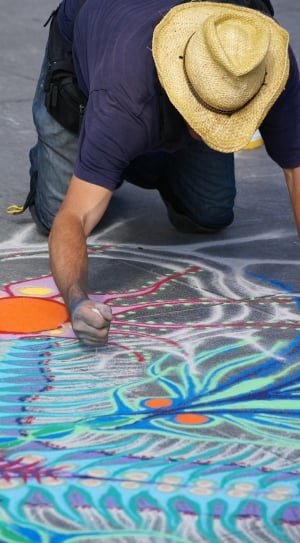 man in blue shirt making a floor art during daytime thumbnail