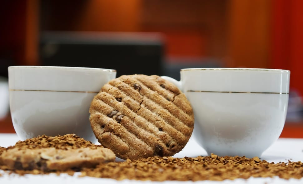 2 brown cookies and 2 white ceramic cup preview