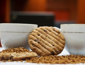 2 brown cookies and 2 white ceramic cup thumbnail