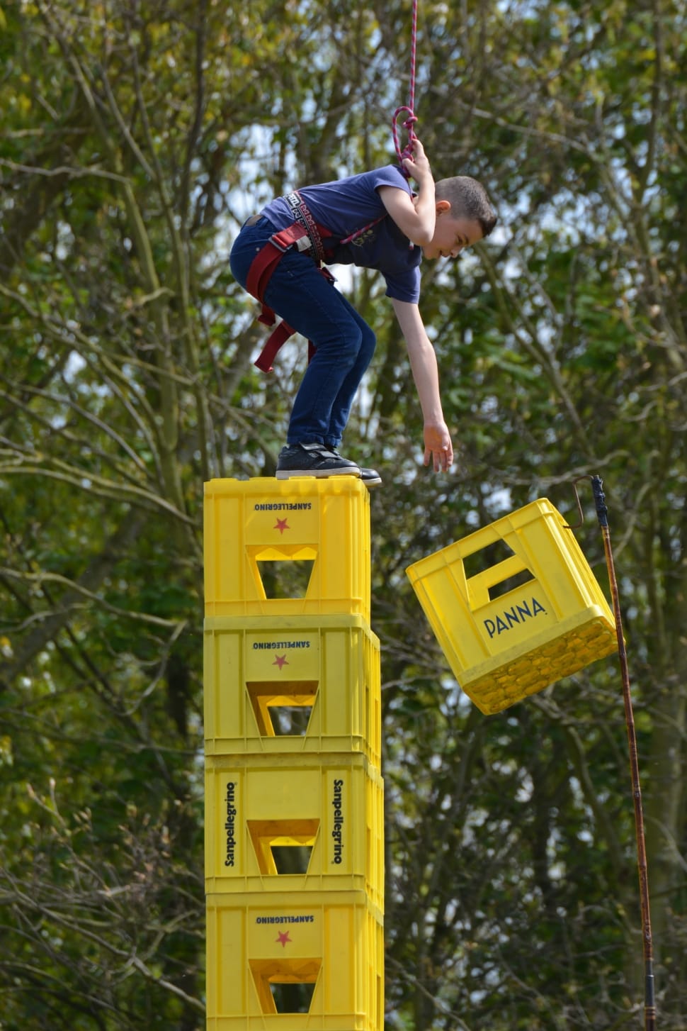 boy wearing blue shirt on top of yellow plastic crates preview