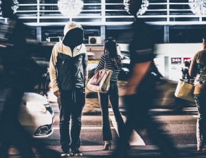 man wearing white and gray hoodie in the middle of the street thumbnail
