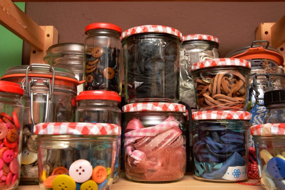glass jars of clothes buttons and ribbons preview