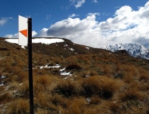 road sign and green snowy mountains thumbnail