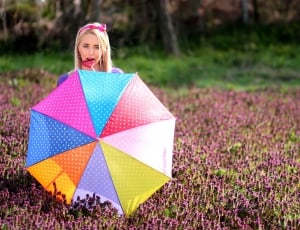 selective focus photography of woman in garden with umbrella thumbnail