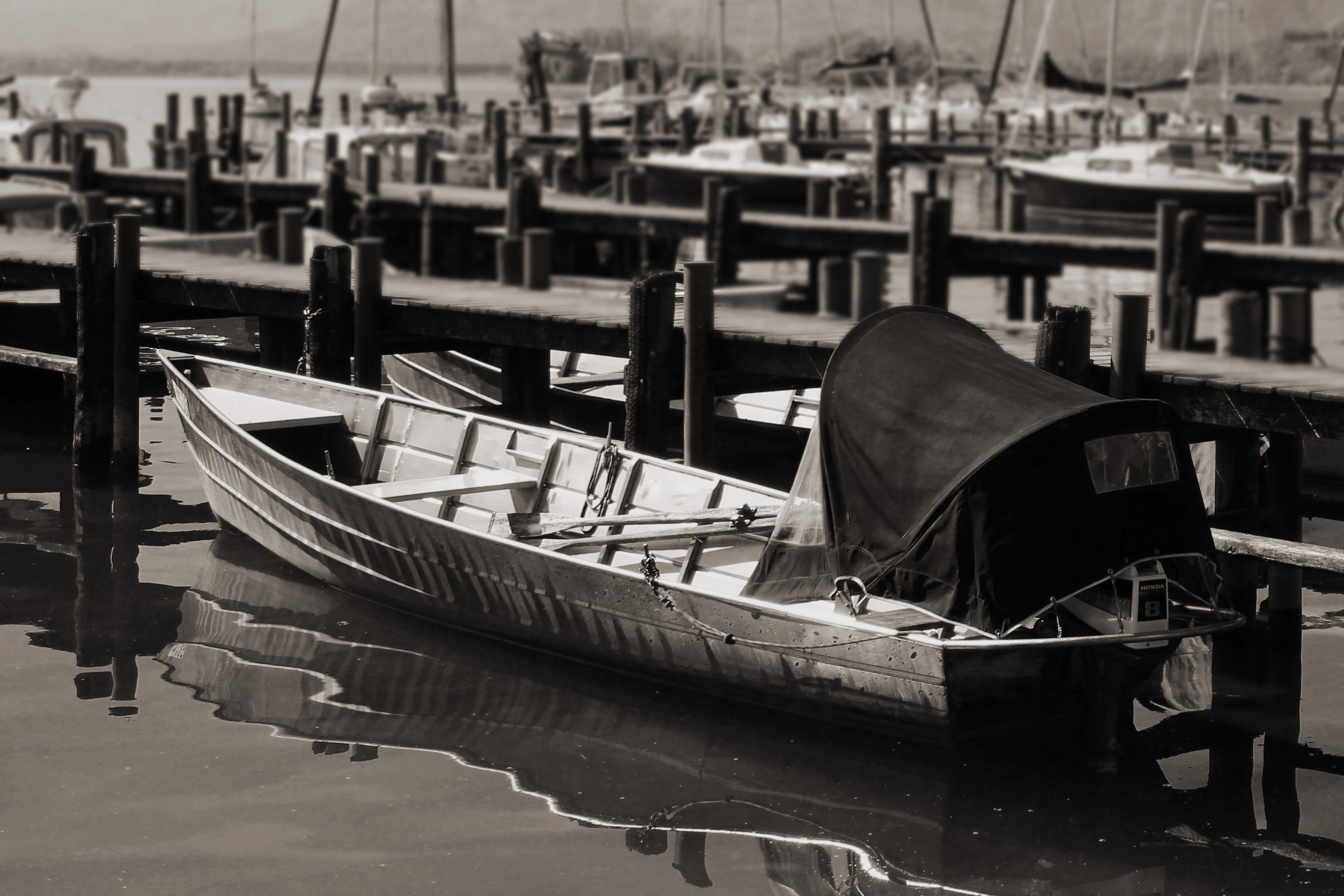 greyscale photo of boat docked at daytime