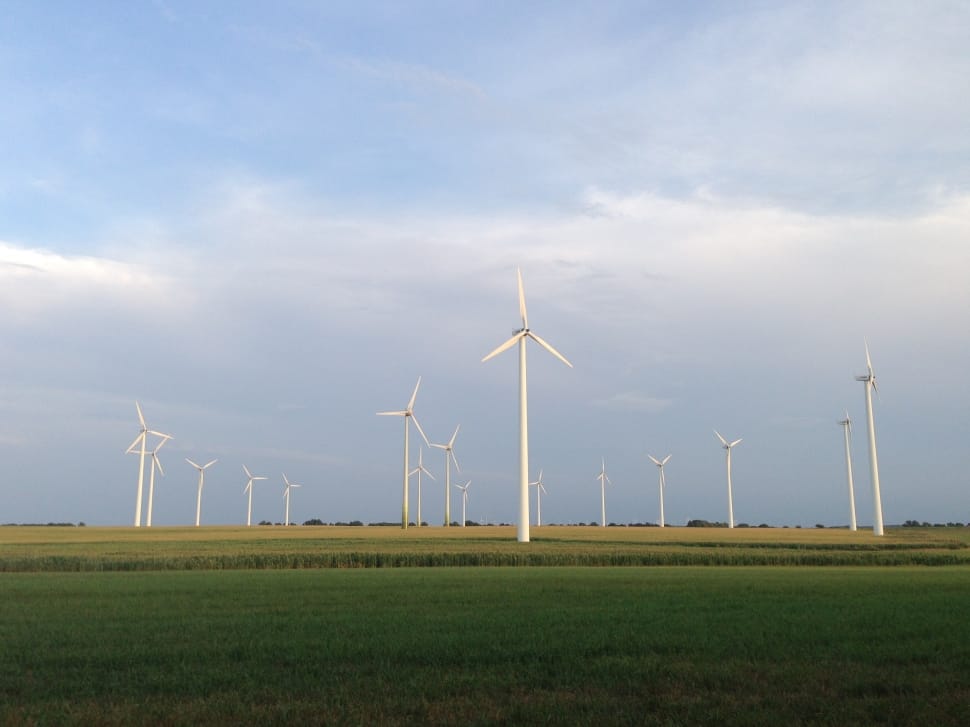 white wind turbines on green grass field preview