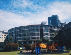 playground in front of building under blue and white sky thumbnail