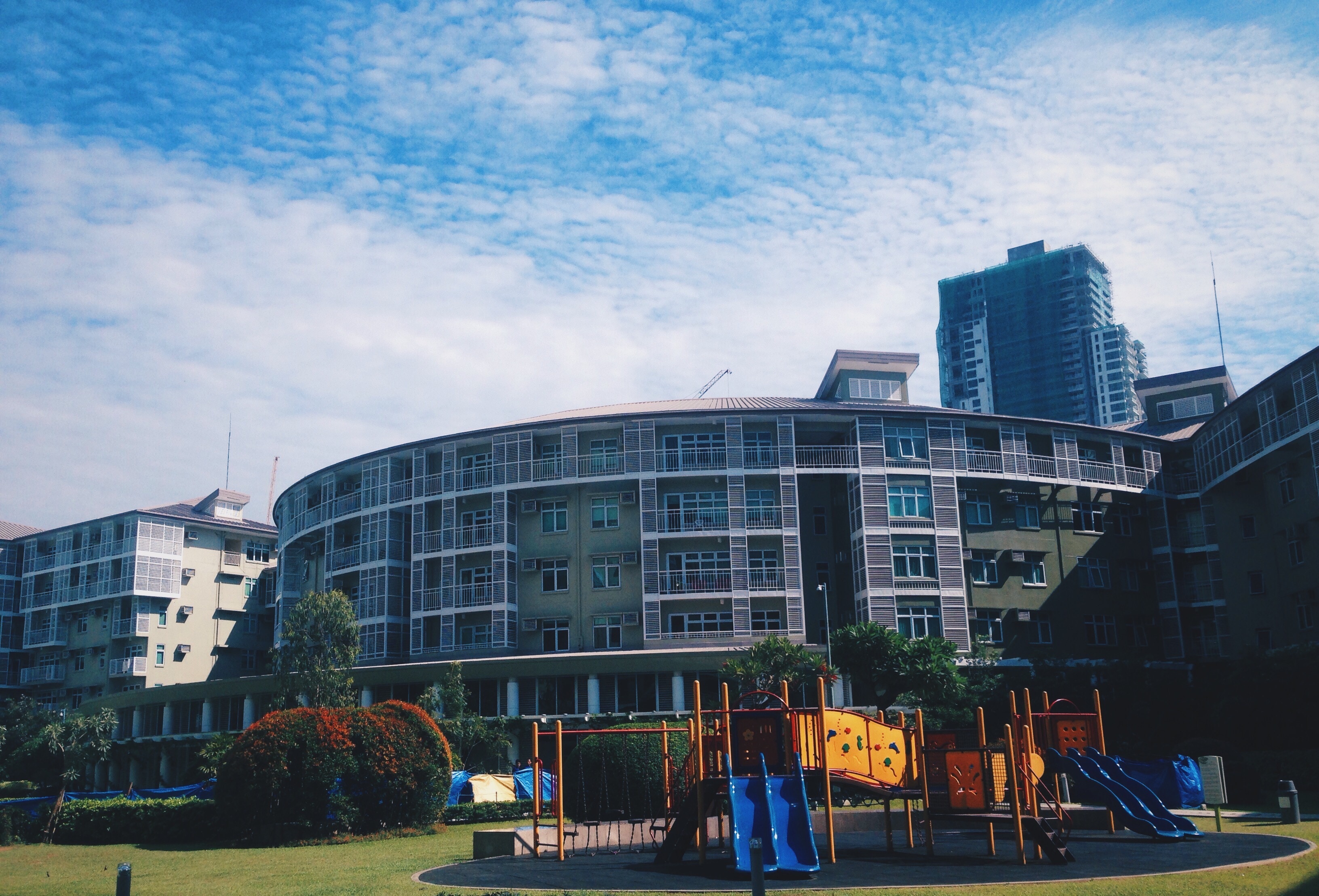 playground in front of building under blue and white sky