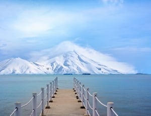 empty pathway on body of water with snow mountain painting thumbnail