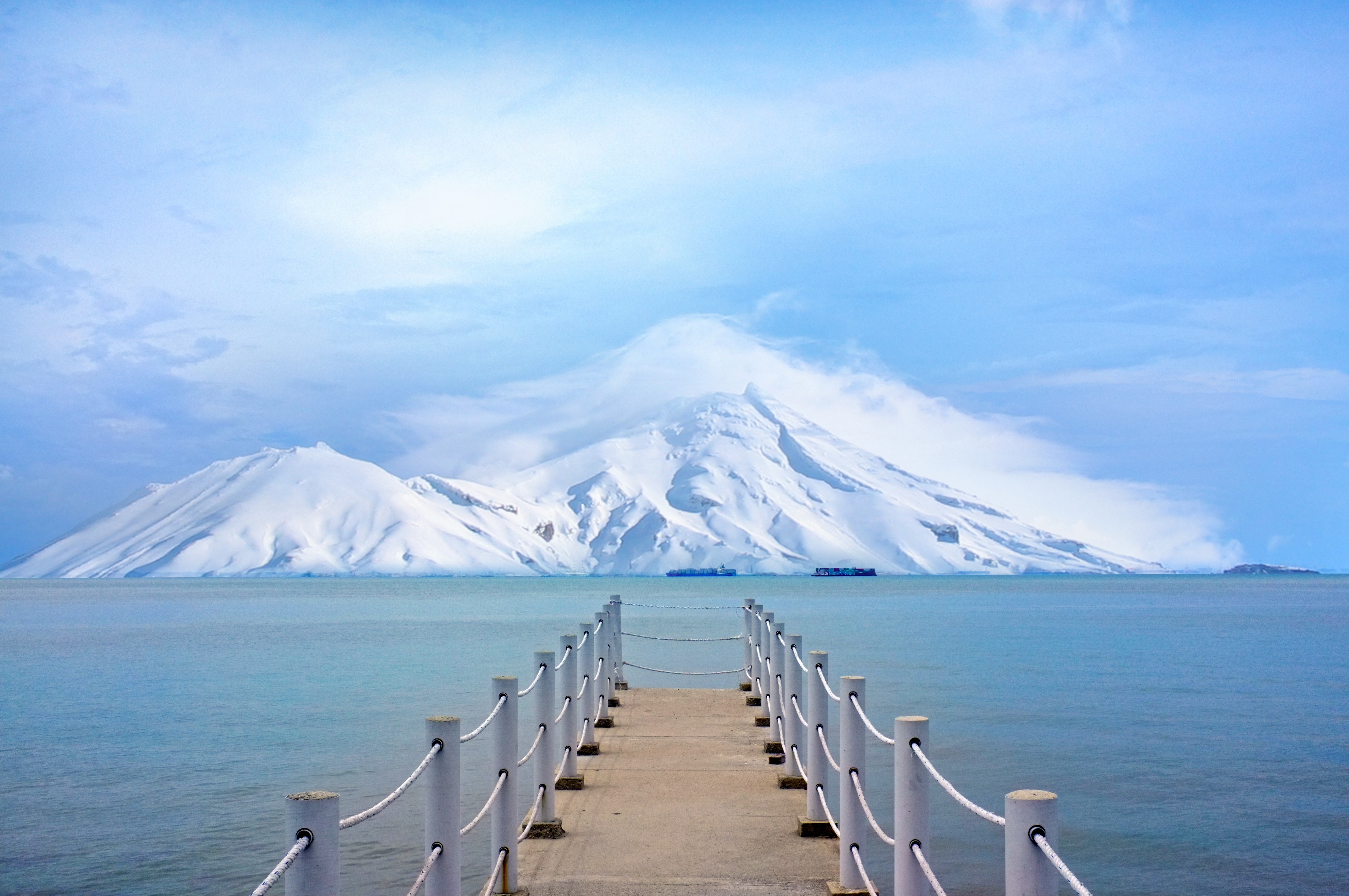 empty pathway on body of water with snow mountain painting