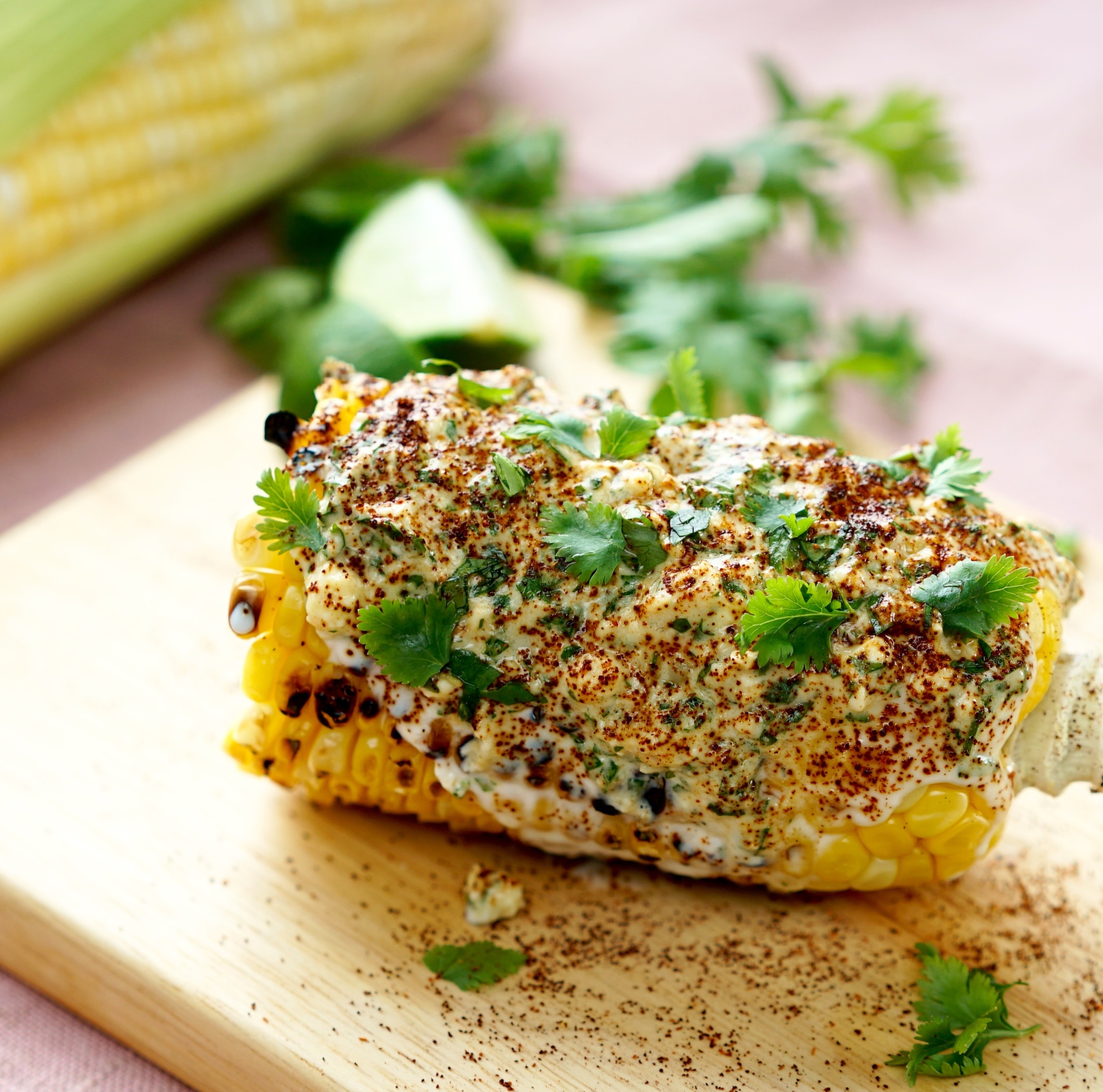 grilled corn with cream and green leaf vegetable