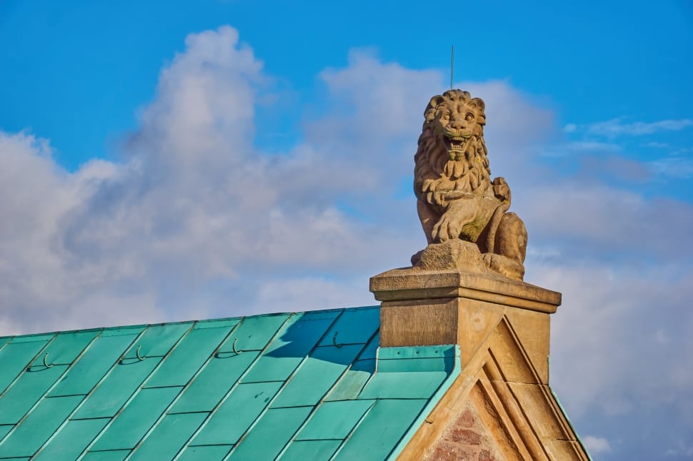 gold lion statue on top of concrete house preview
