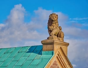gold lion statue on top of concrete house thumbnail