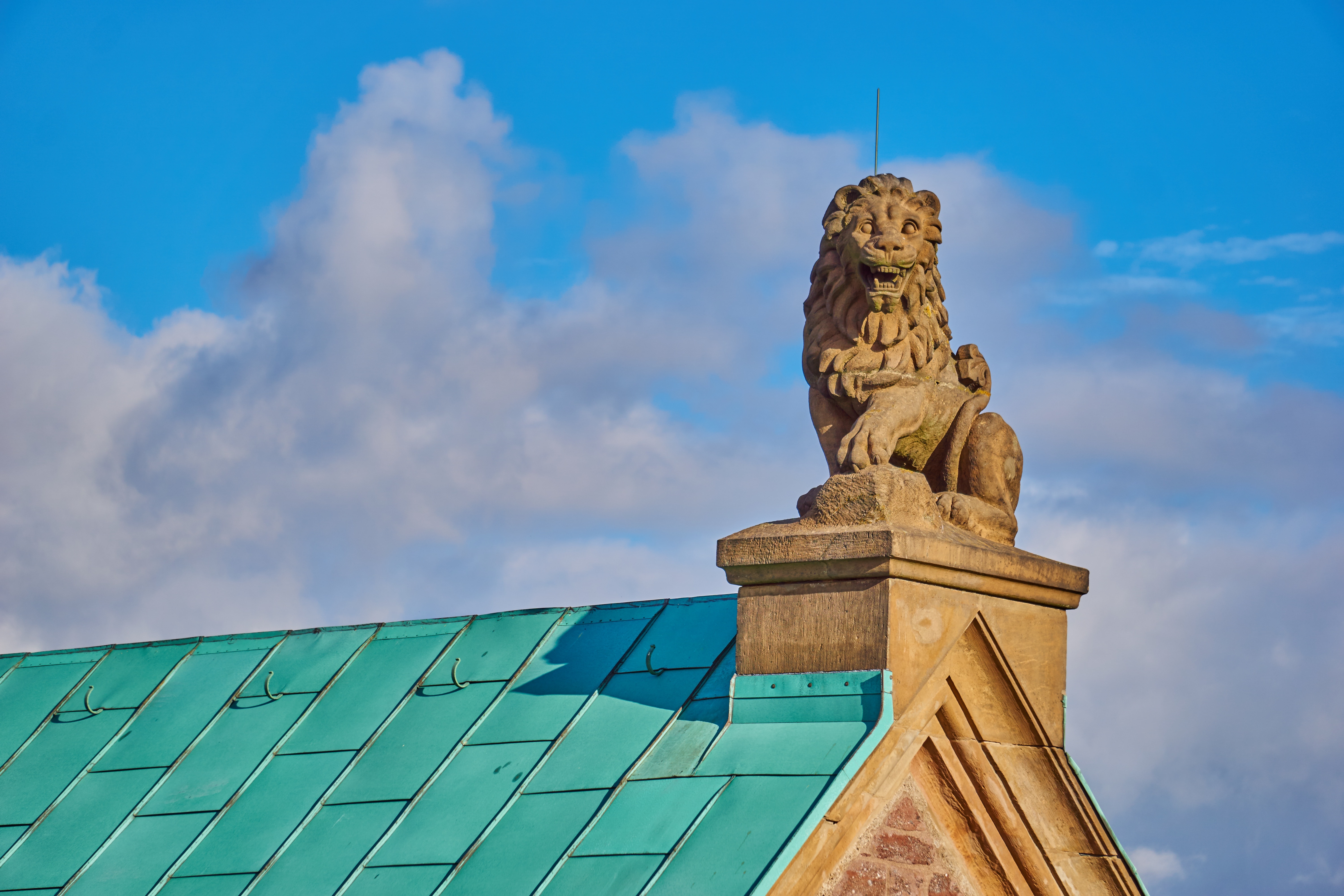 gold lion statue on top of concrete house