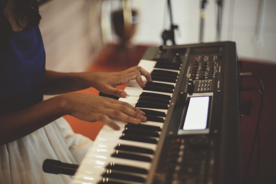 person playing black and white electronic keyboard preview