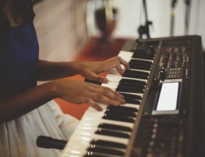 person playing black and white electronic keyboard thumbnail