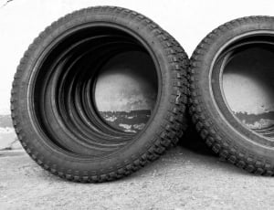 grayscale photo of motorcycles wheels leaning on wall thumbnail