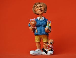 woman holding baby and alphabet block ceramic figurine thumbnail