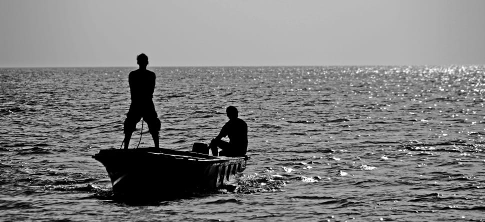 silhouette of 2 man in boat preview