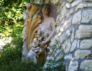 concrete statue of girl near trees thumbnail