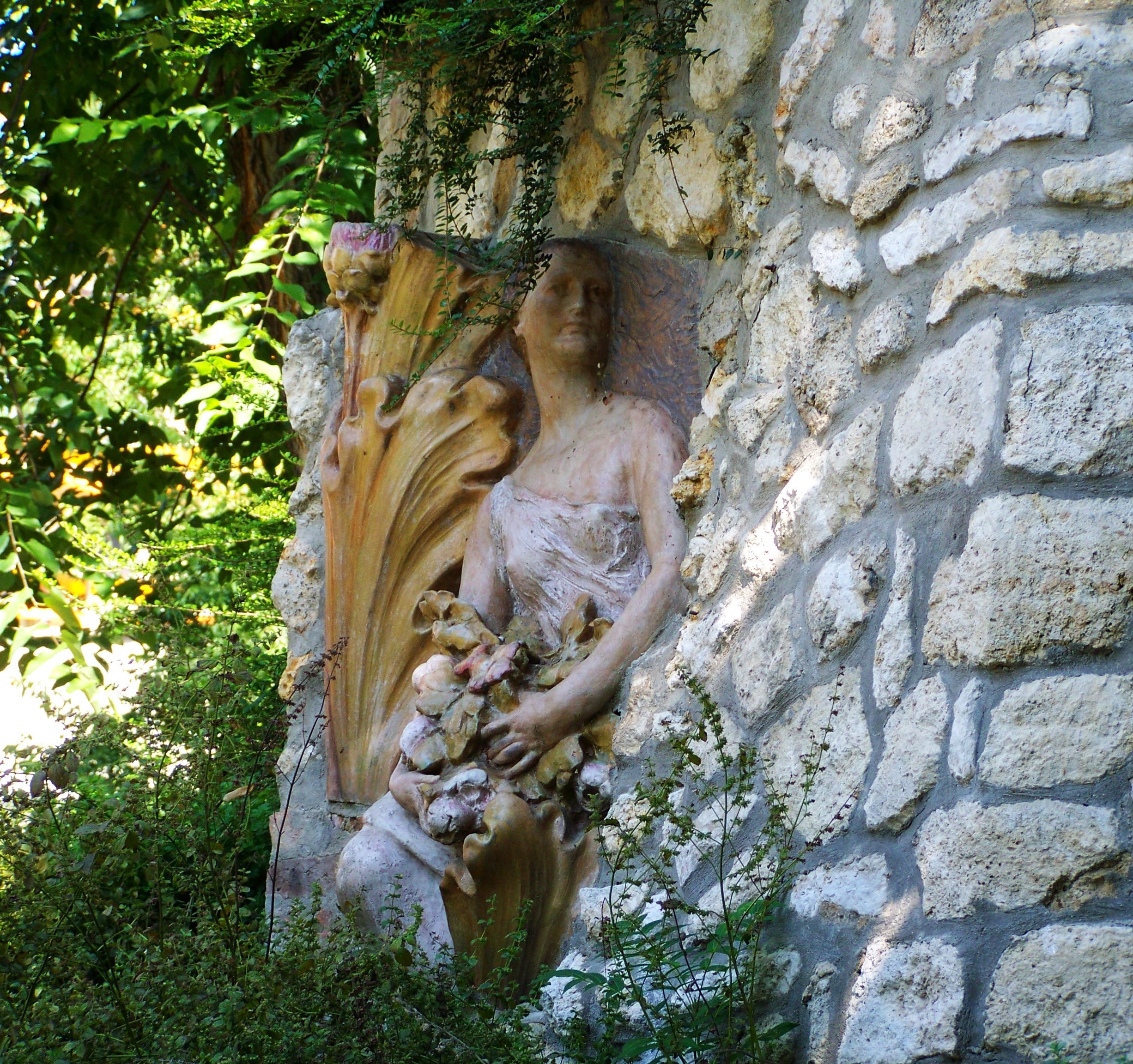 concrete statue of girl near trees