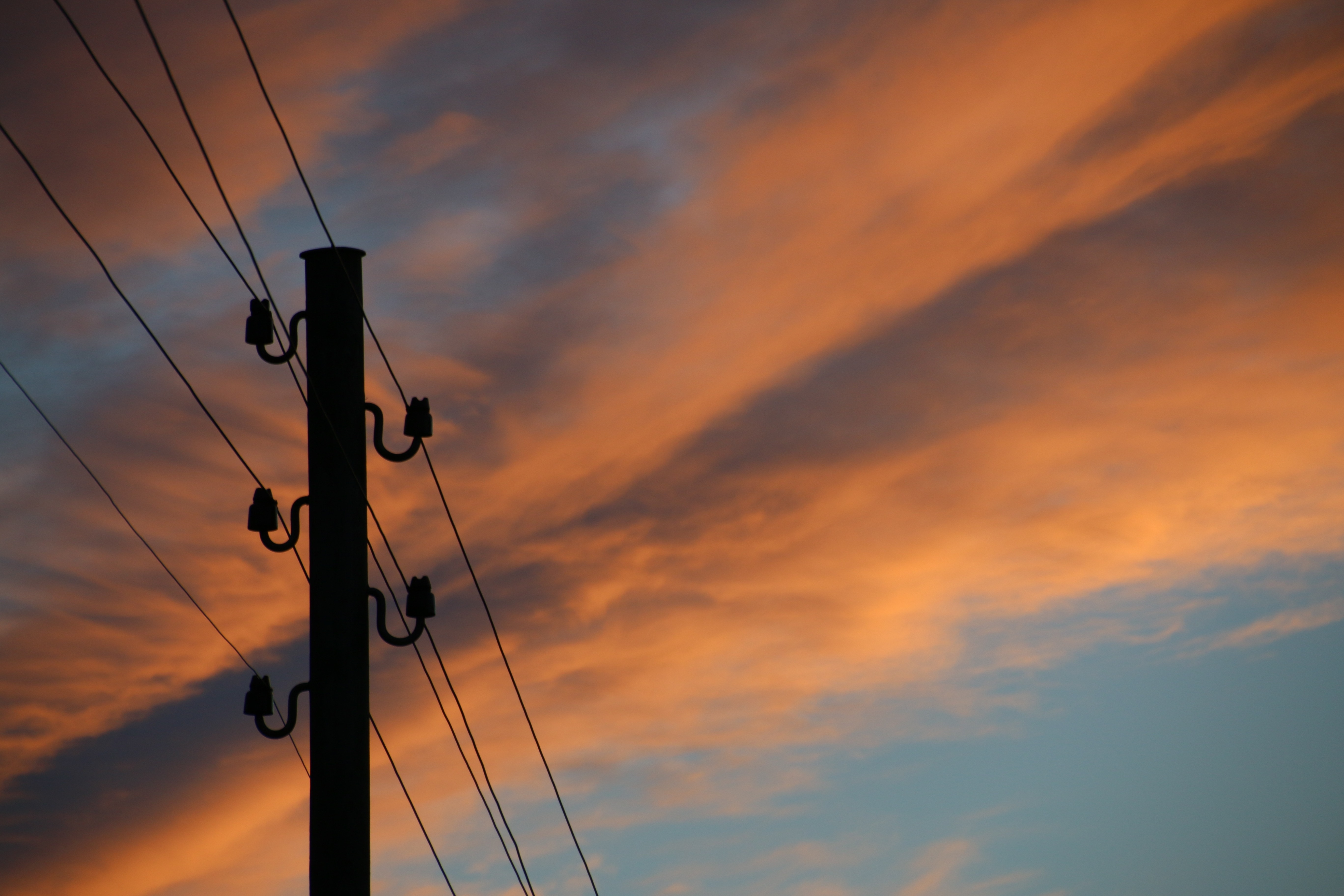 silhouette photo of electric post under noon