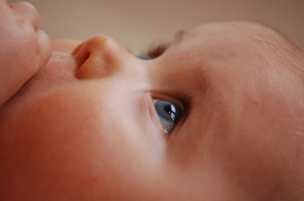 toddler looking up while her left hand on top her mouth preview