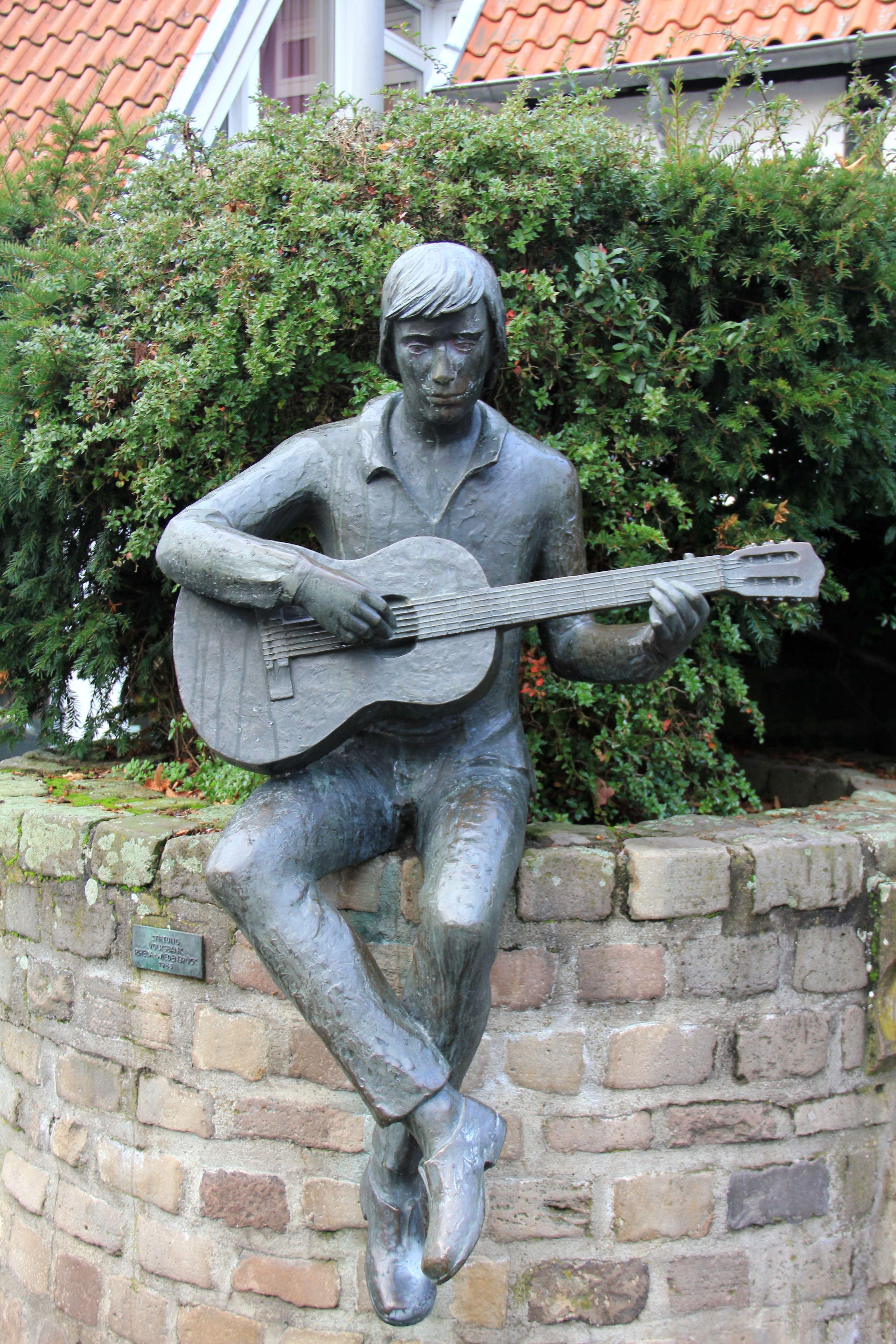 man playing guitar statue