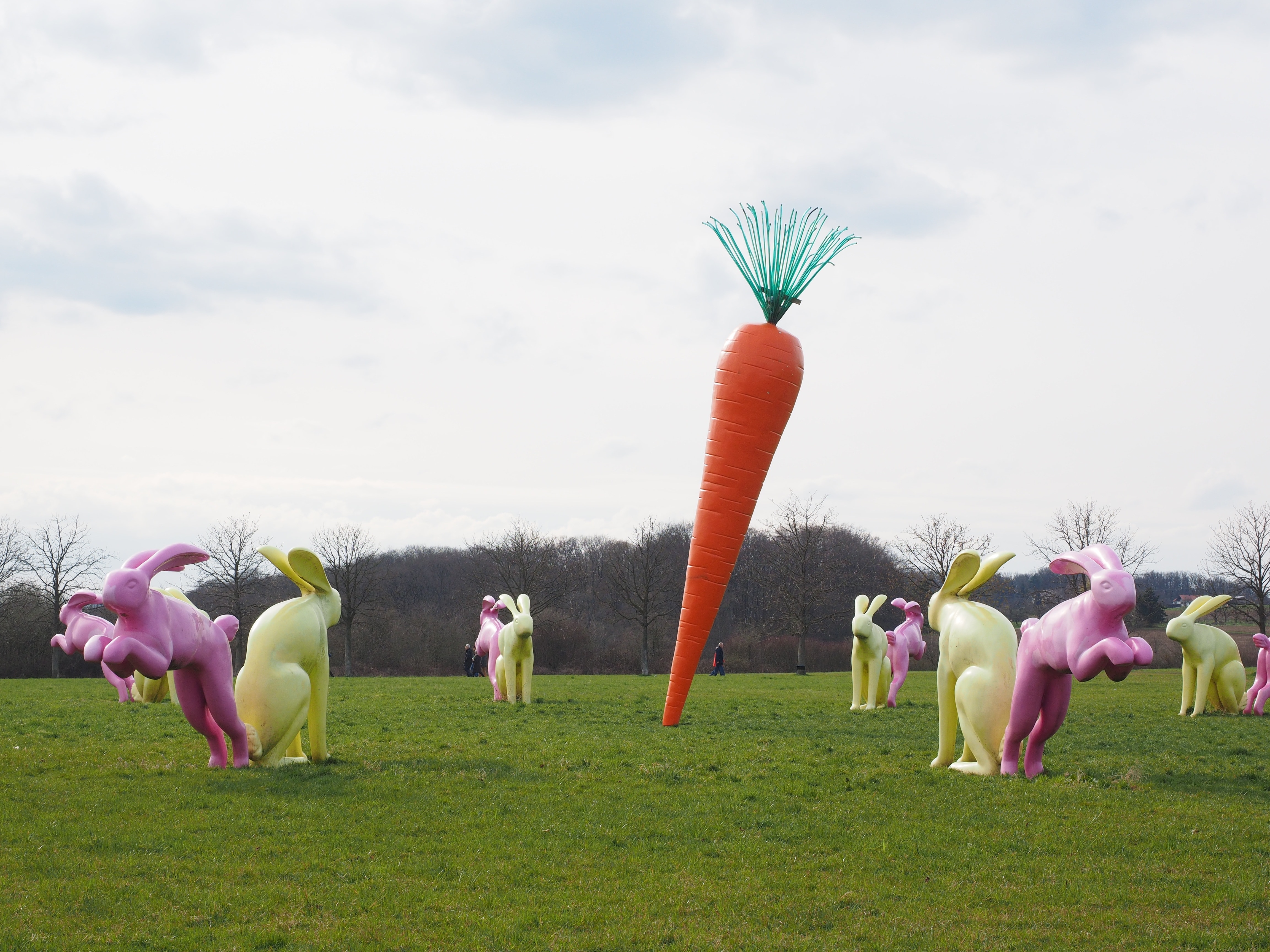 rabbit statues and carrot statue on green grass field