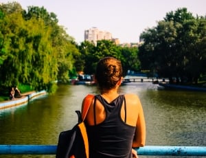 woman in black racer back shirt facing river thumbnail