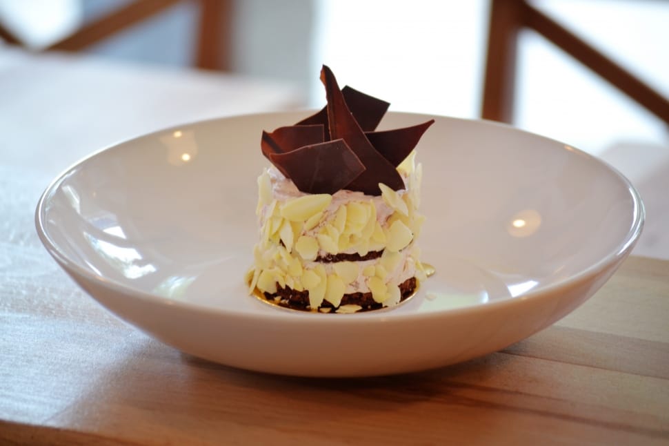 chocolate pastry on white ceramic bowl on top of brown wood surface on selective focus photography preview