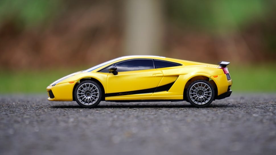 yellow coupe diecast on grey concrete road preview