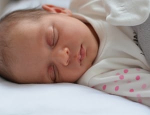 baby wearing white and pink onesie thumbnail