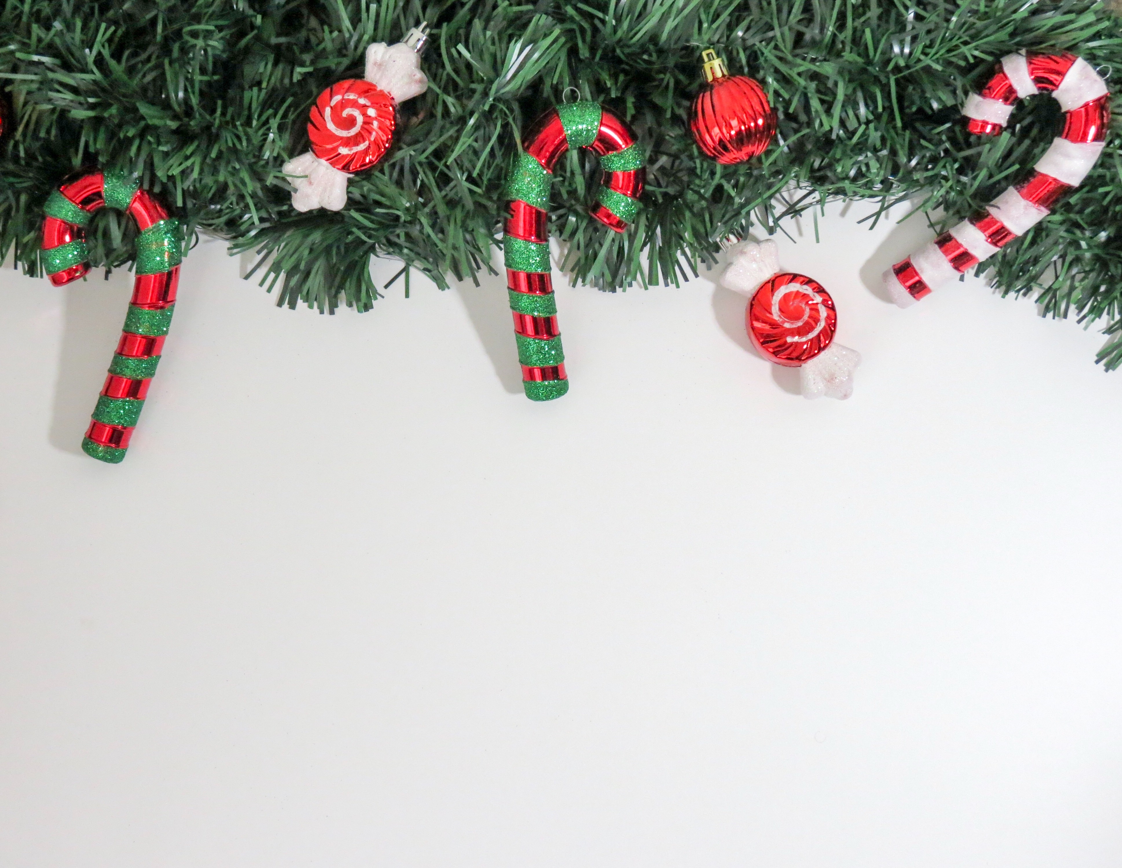 3 candy canes, 3 baubles and green christmas garland decors