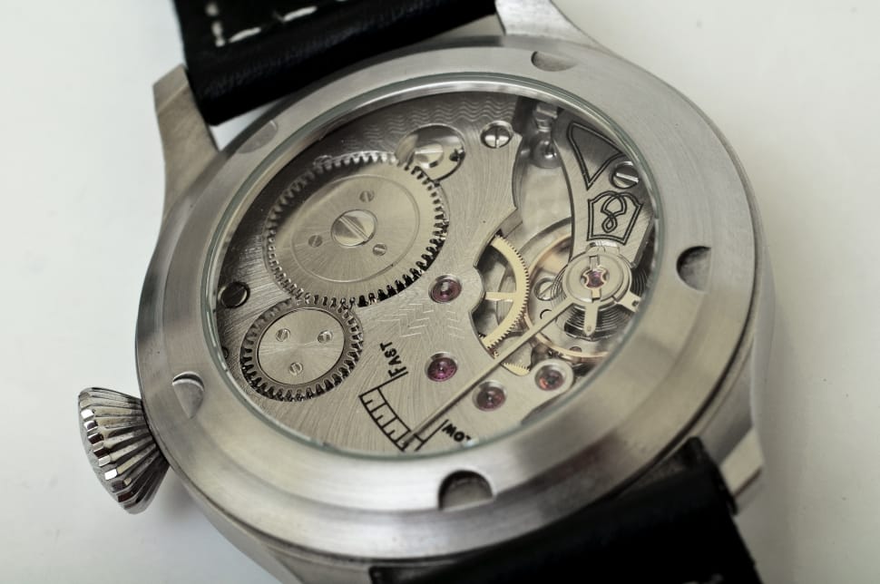 close-up of round silver mechanical watch on black surface preview