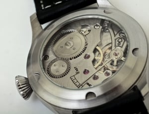 close-up of round silver mechanical watch on black surface thumbnail