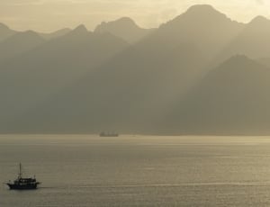 silhouette of fishing boat in sea photograph thumbnail