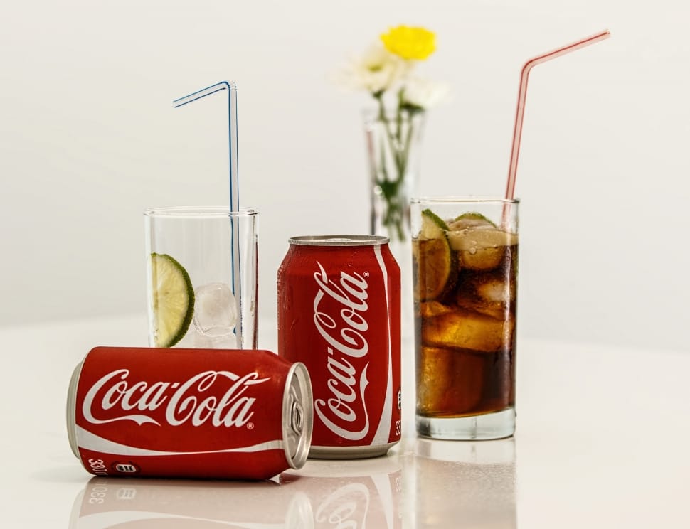 two Coca-Cola cans with two drinking glasses preview