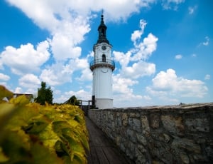 white lighthouse under cloudy sky during daytime thumbnail