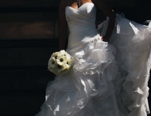 woman wearing bridal gown holding flower bouquet thumbnail