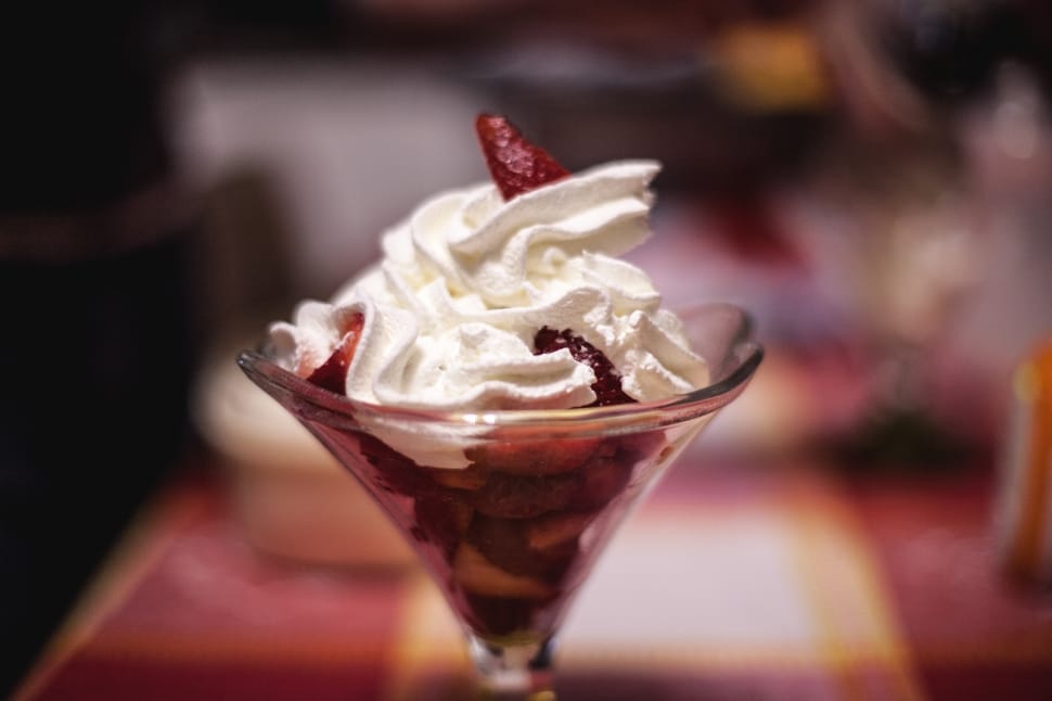 strawberries topped with whipcream in clear footed glass preview