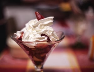 strawberries topped with whipcream in clear footed glass thumbnail