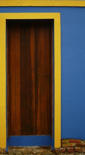 blue and yellow facade with brown wooden door thumbnail