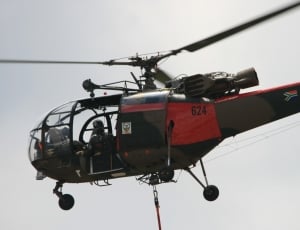 black and red Helicopter flying during day time thumbnail