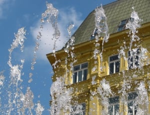 fountain water by yellow building thumbnail